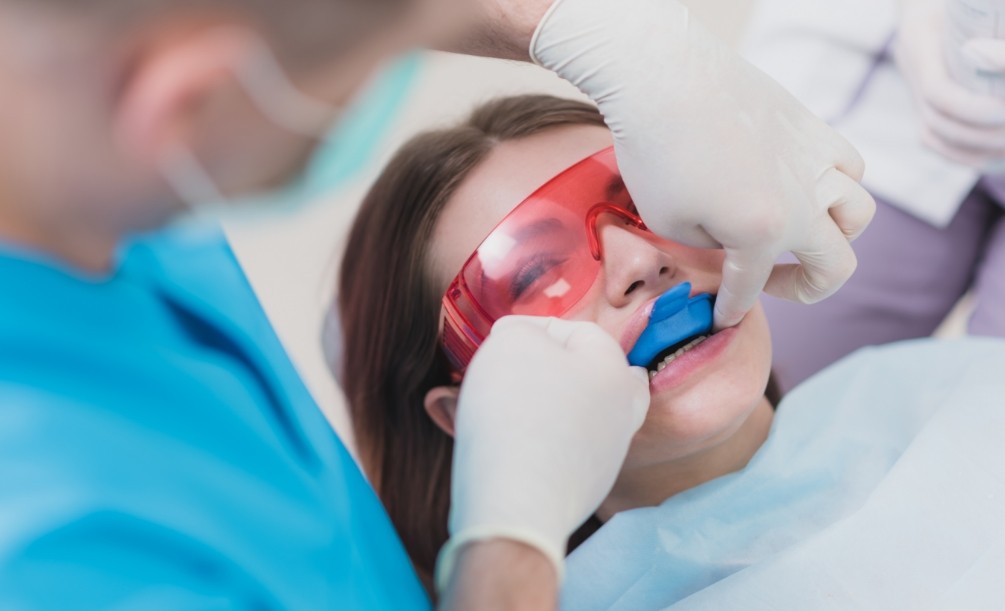 Young woman getting fluoride treatment during dental visit