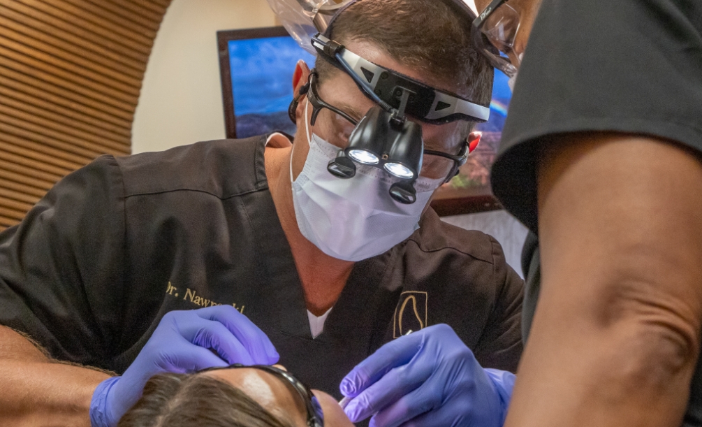 Close up of Doctor Nawrocki wearing dental binoculars while treating a dental patient