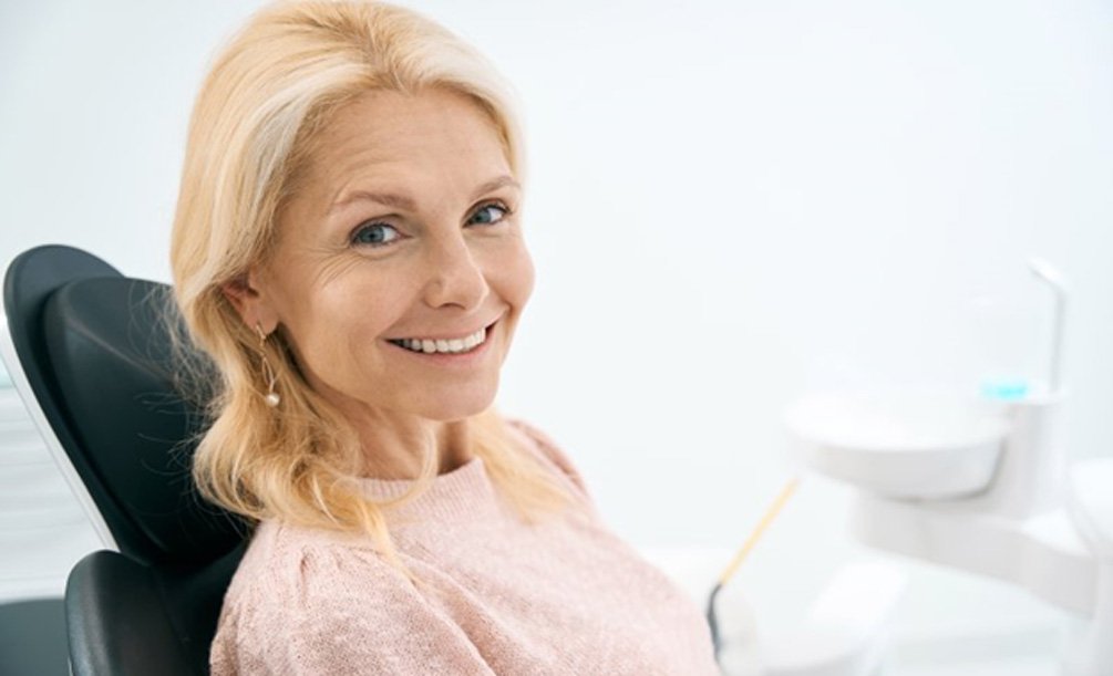 a woman smiling after receiving all-on-6 implants