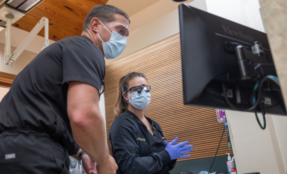 Two dentists looking at computer screen in dental treatment room