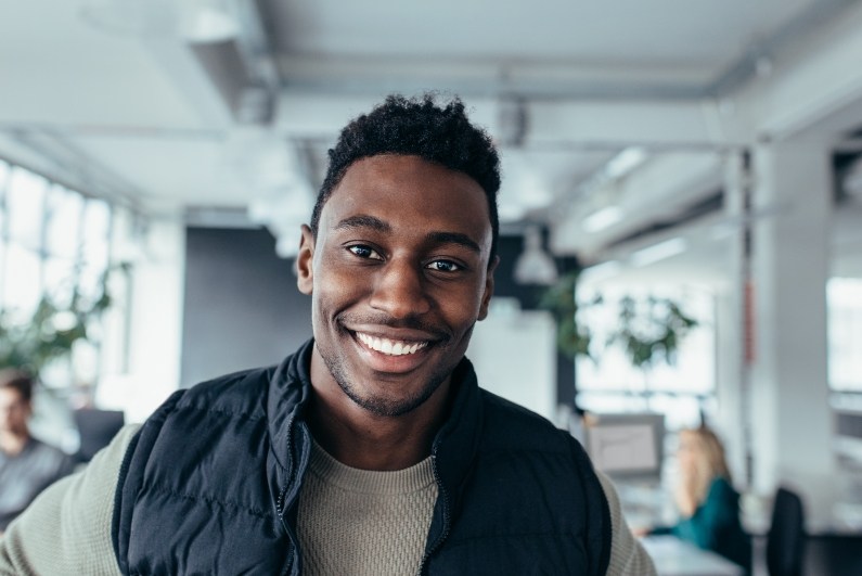 Young man smiling in open office after dental checkups in Ormond Beach