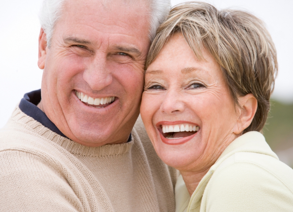 Older man and woman smiling outdoors after cosmetic dentistry in Ormond Beach