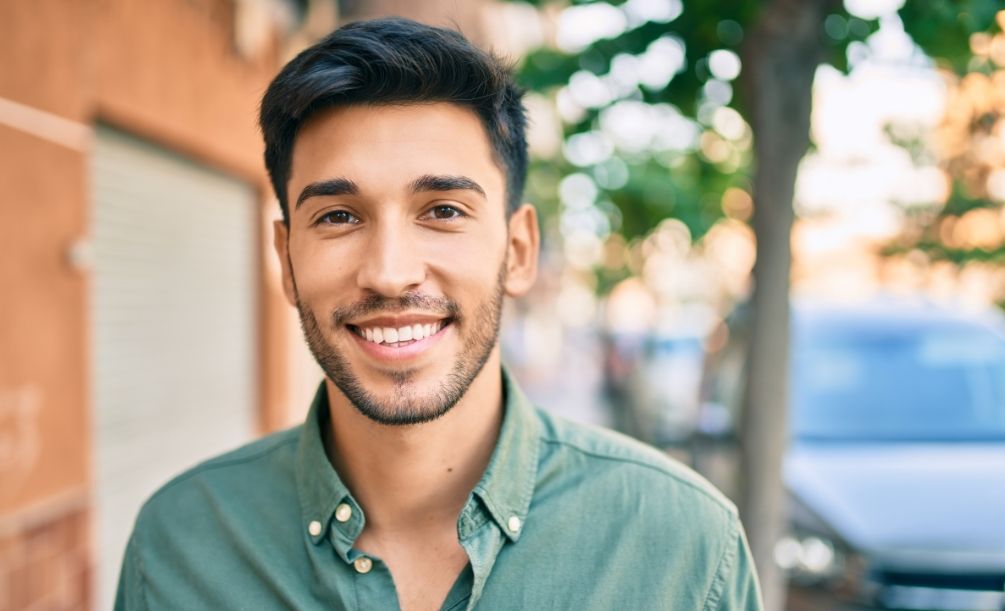Smiling young man in green button up shirt