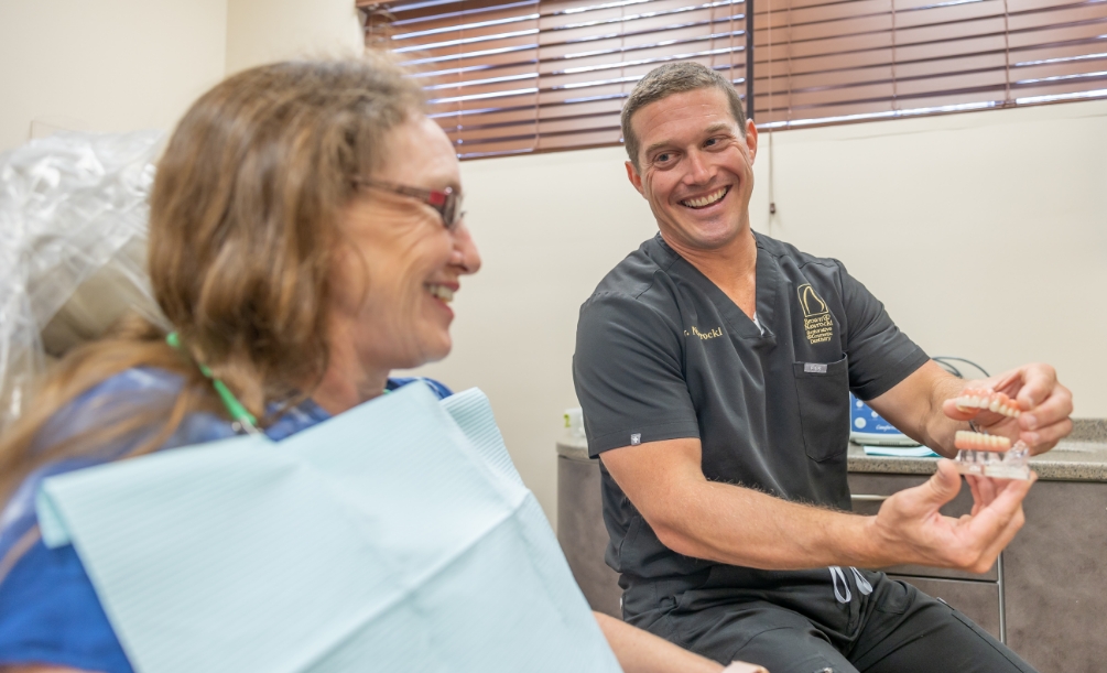 Doctor showing tooth Model to dental patient