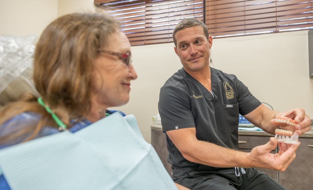 Doctor Nawrocki talking to a dental patient about implant dentures