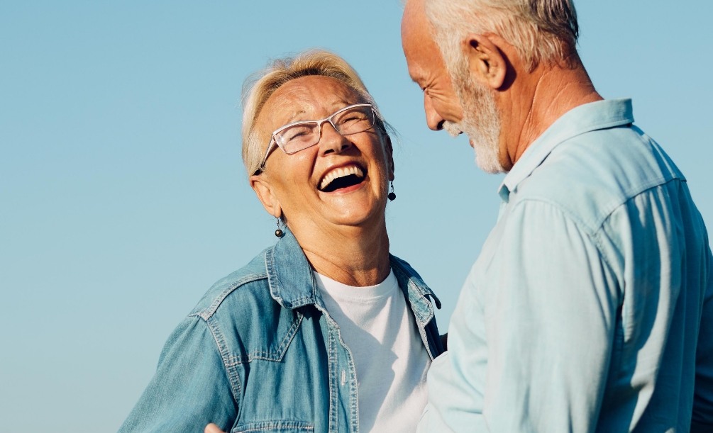 Senior man and woman laughing together outdoors