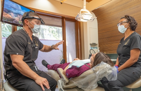 Ormond dentist and assistant talking to a patient in dental chair