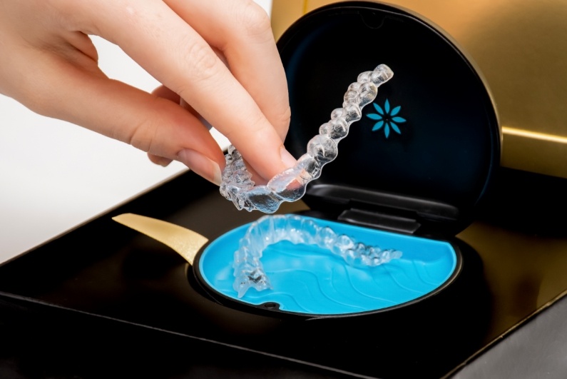 Person placing Invisalign aligner in its storage case