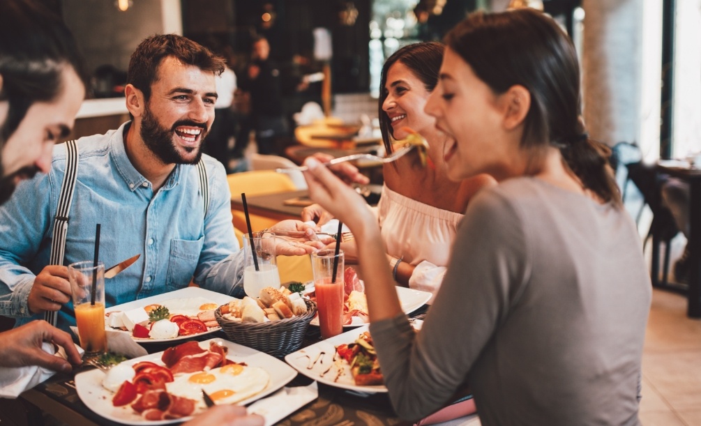 Woman eating at restaurant with three other people