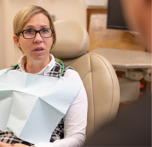 patient in dental chair talking to dentist
