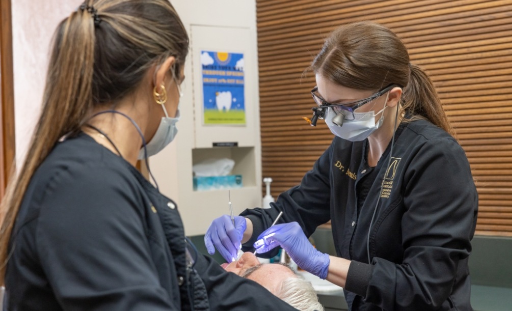 Doctor Dennis and dental assistant treating a patient