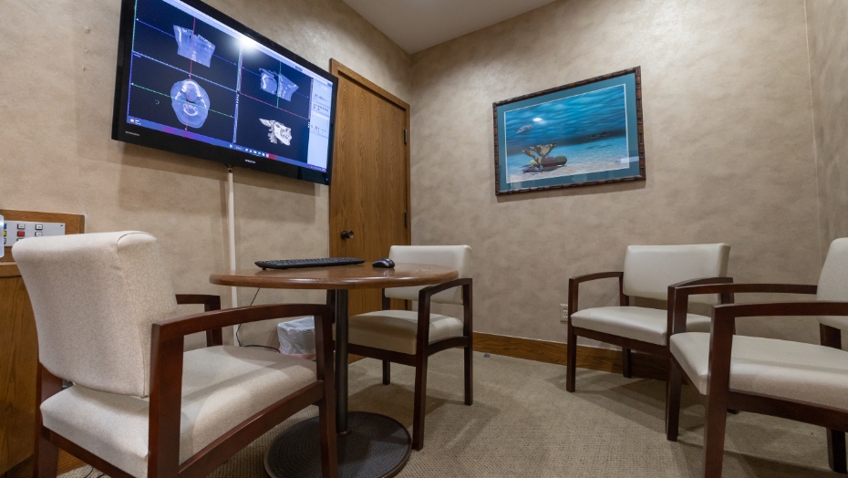 Dental consultation room with digital models of teeth and jaws on T V screen on wall