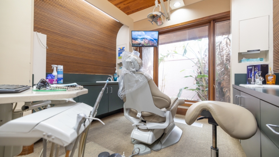 Table with several dental instruments behind dental exam chair