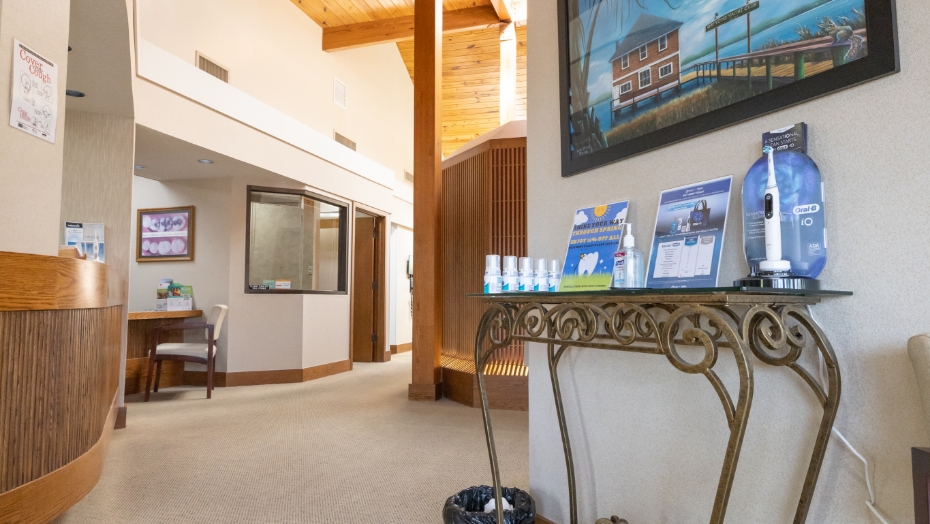 Table with electric toothbrush display and hand sanitizer in dental office reception area