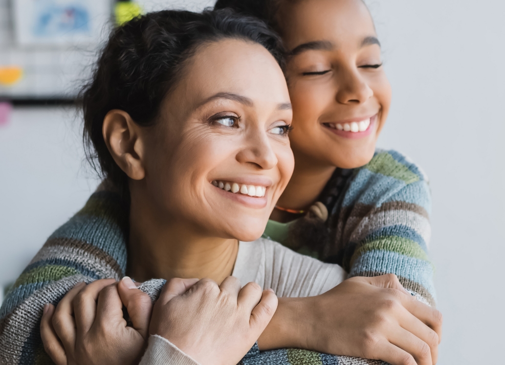 Girl hugging her mother from behind