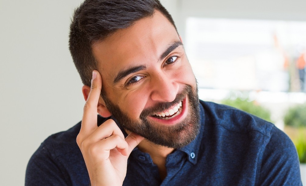 Smiling man in dark blue collared shirt