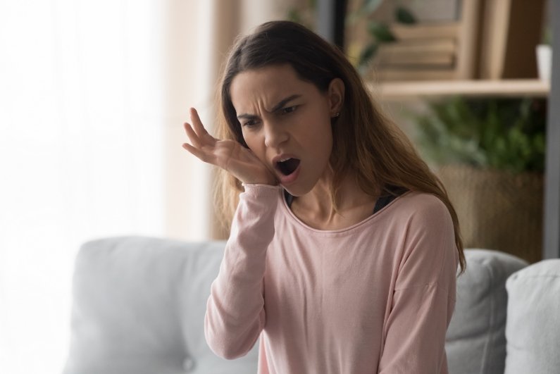 Woman holding her jaw in pain needing T M J treatment in Ormond Beach