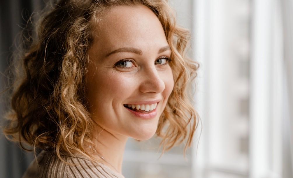 Woman with curly light brown hair smiling
