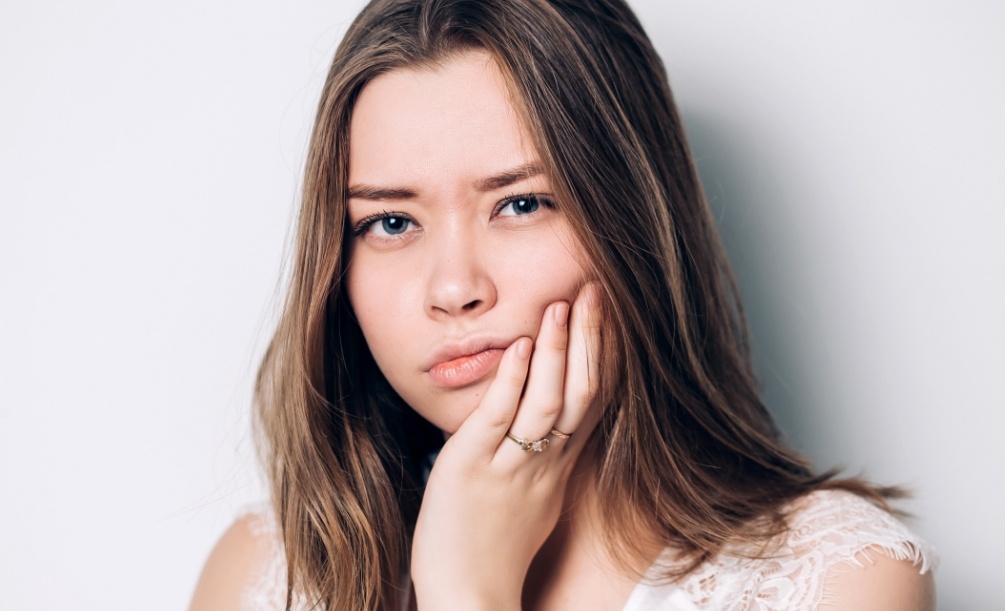 Young woman holding the side of her jaw in pain