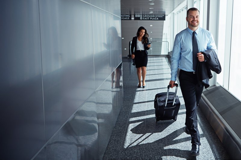 A man with dental implants walking successfully to his plane