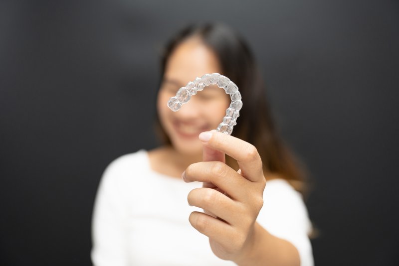 A woman smiling with her Invisalign aligner