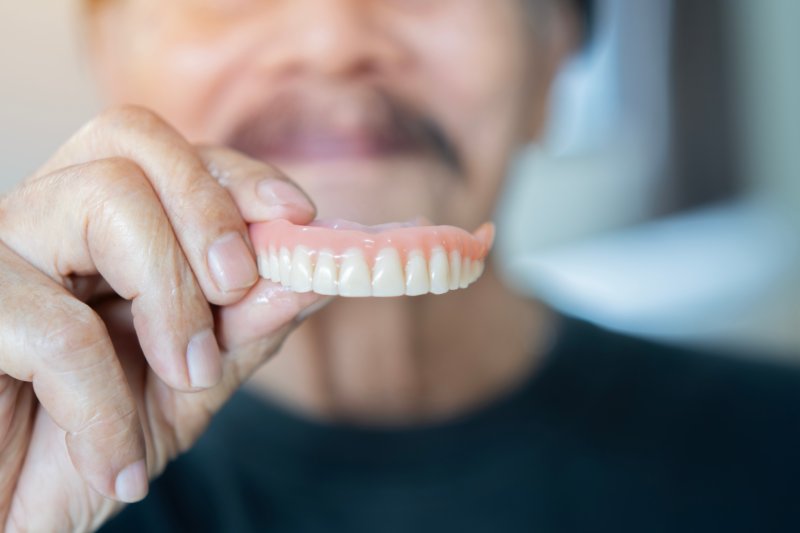 Patient holding their denture before applying denture adhesive