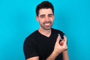 Man smiling while putting in his Invisalign