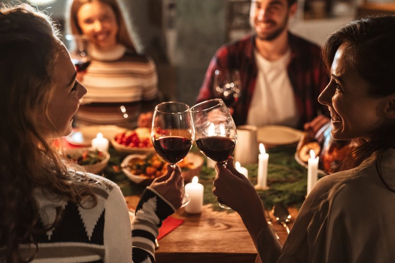 Joyful people drinking wine over a holiday dinner